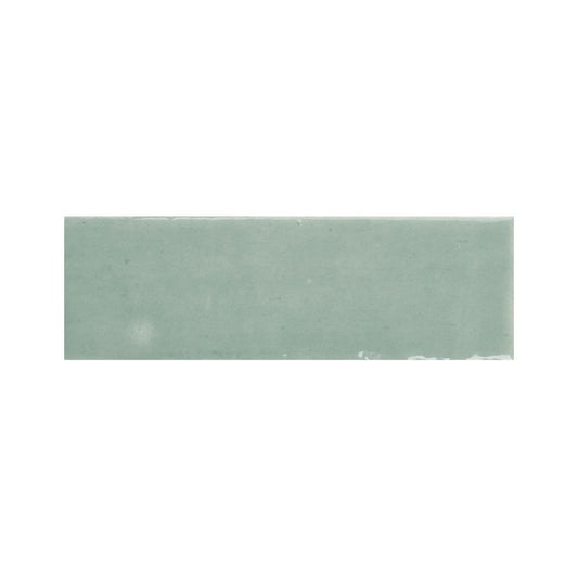 Arrangement of multiple 2x5 inch kiwi green gloss ceramic tiles showing color variation