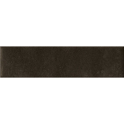 Stack of Cera 2x9 Nero Inchiostro matte porcelain wall tiles, showing the tile's thickness and edge