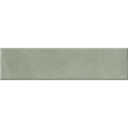 A stack of Cera 2x9 Verde Candito matte porcelain wall tiles, highlighting their uniform size and velvety satin surface.